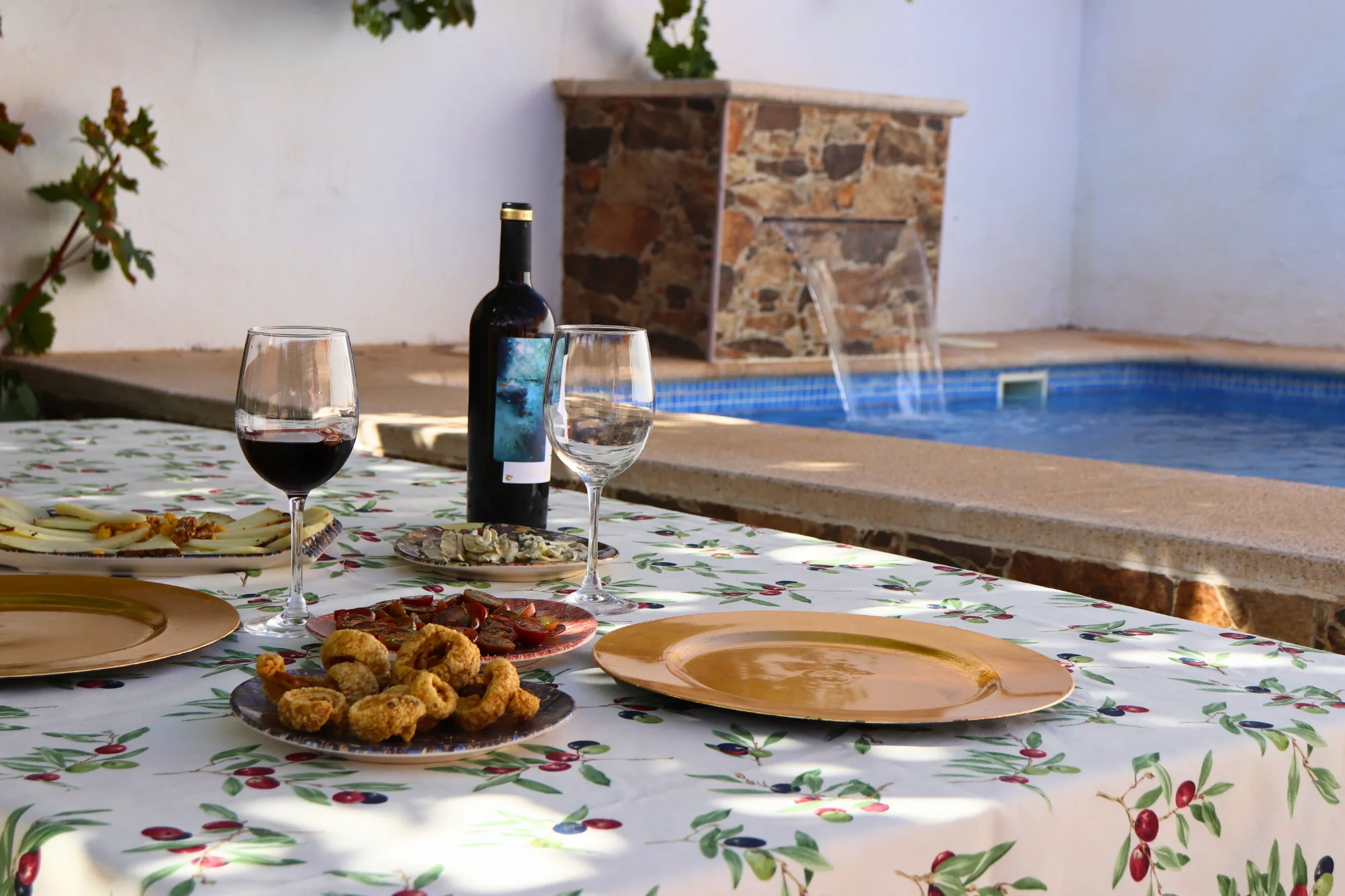 Mesa con vino y aperitivo junto a la piscina de Casa Eufemia